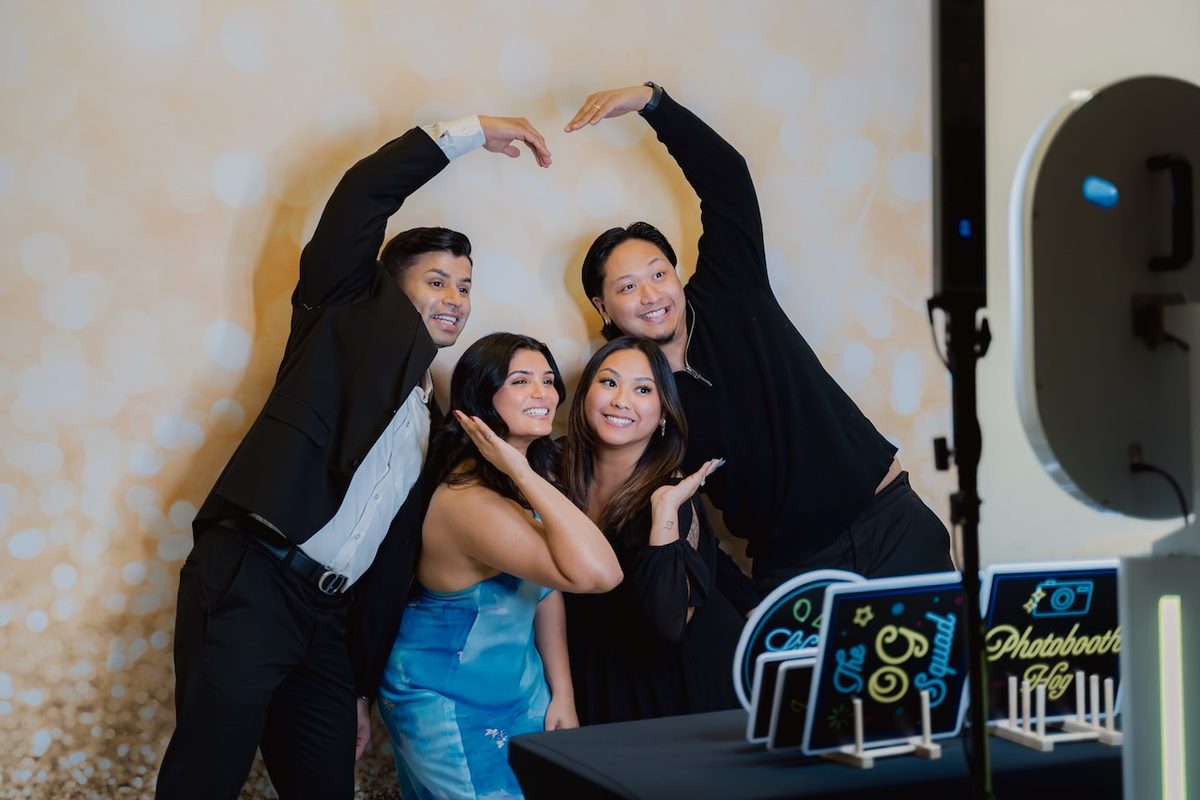 Friends making a heart shape at the booth